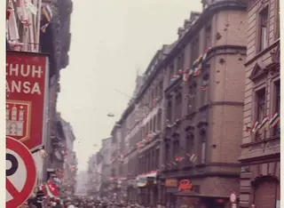 Foto: mit Fahnen geschmückte Straße beim Rosenmontagszug in Mainz 1962